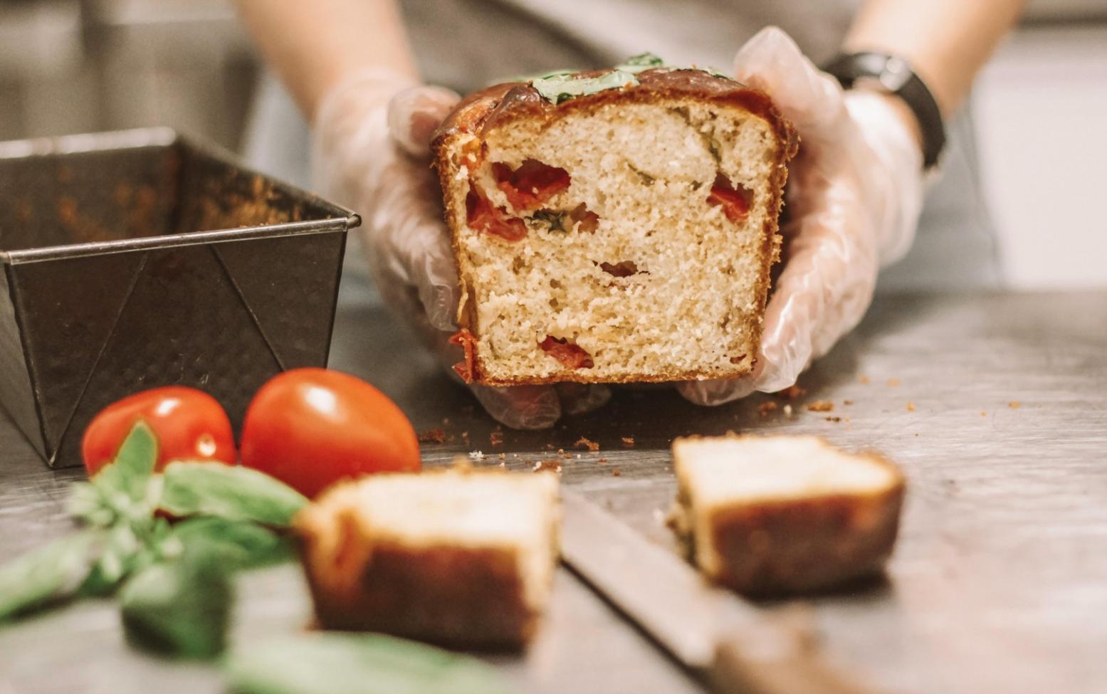 Student plating duck breast with seasonal vegetables and reduction sauce